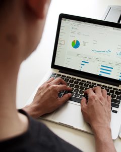 Femme sur un ordinateur portable sur une page avec des graphiques